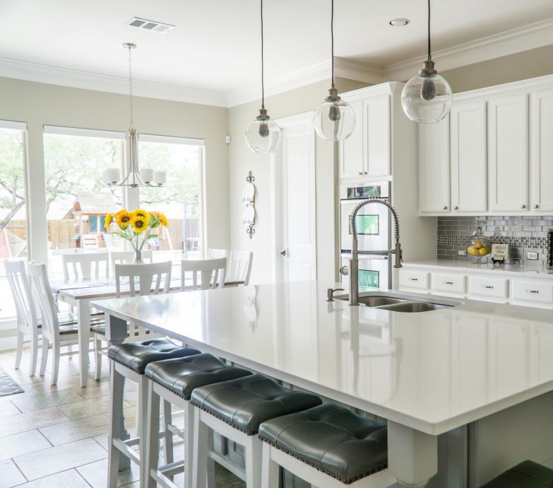 Spacious modern kitchen with white cabinets and island in natural light.